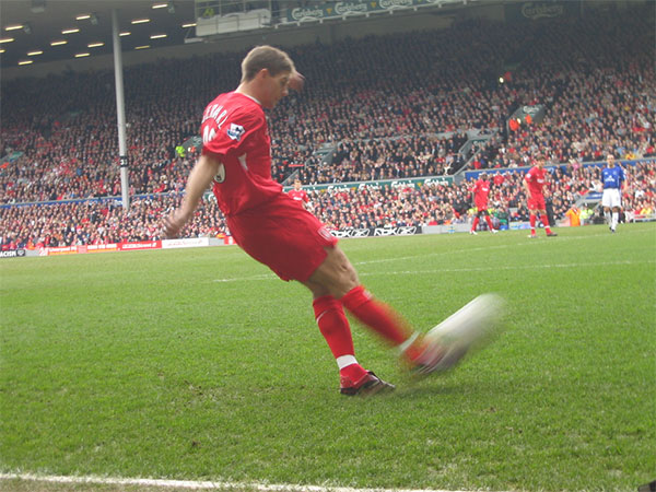Steven Gerrard crossing the ball in a Premier League match.