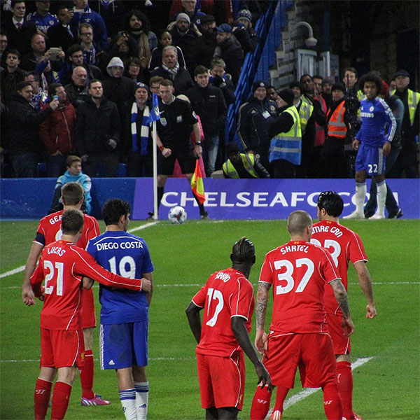 Liverpool (red) players prepare to defend a Chelsea (blue) corner.